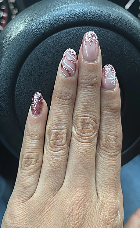 Uñas nude con puntas de glitter rosa y una línea de brillo en espiral